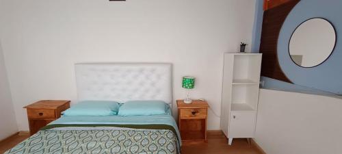 a small bedroom with a bed and a mirror at Patagonia Salvaje Hostel in El Calafate