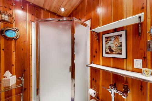 a shower in a bathroom with wooden walls at Coastal Cabin in Gualala