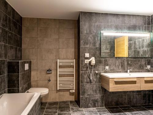 a bathroom with a tub and a toilet and a sink at Charming Alps Apartment in Abondance