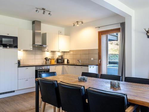 a kitchen and dining room with a wooden table and chairs at Charming Alps Apartment in Abondance