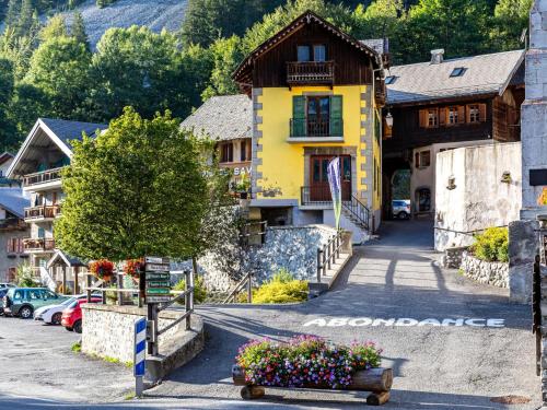 a yellow house on a street in a village at Charming Alps Apartment in Abondance