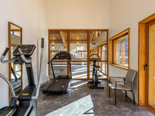 a gym with treadmills and ellipticals in a room at Charming Alps Apartment in Abondance
