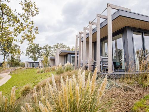 a house on top of a hill with tall grass at Chalet by Beach and Harbor with Terrace in Well
