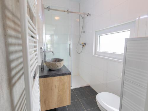 a bathroom with a sink and a toilet and a window at Chalet by Beach and Harbor with Terrace in Well
