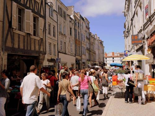 a crowd of people walking down a busy city street at Villa with garden near beautiful golf course in Vasles