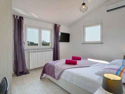 Un dormitorio con una cama con almohadas rojas. en A wonderful family villa with swimming pool and covered terrace, en Pula