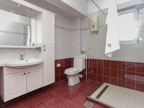 a bathroom with a toilet and a sink and a mirror at Enchanting Apartment in Ka tel Gomilica near Beach in Kaštela