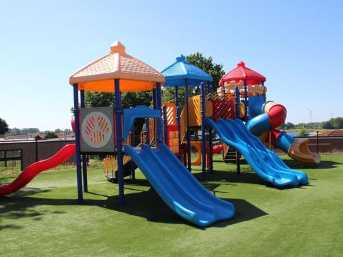 a group of playground equipment on a grass field at Modern chalet with a dishwasher in Lathum in Lathum
