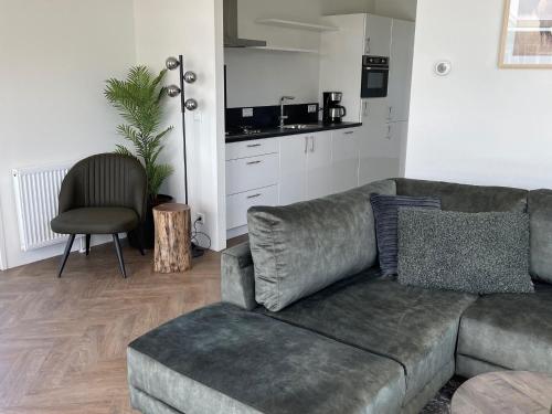 a living room with a couch and a chair at Modern chalet with a dishwasher in Lathum in Lathum
