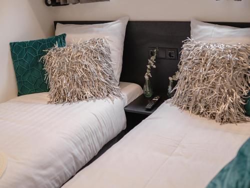 2 camas con almohadas en un dormitorio en Luxury holiday home on the water, located in a holiday park in the Betuwe, en Maurik