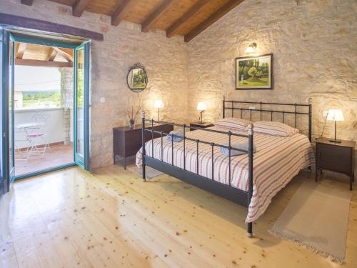 ein Schlafzimmer mit einem Bett in einer Steinmauer in der Unterkunft Roofed Villa in Istria with Private Pool and Garden in Rajki