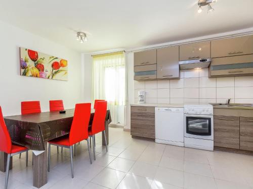 a kitchen with a dining table and red chairs at Apartment in Pomer near the Beach in Pomer