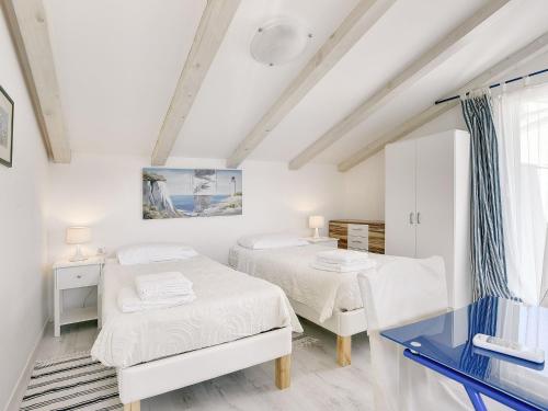 2 Betten in einem weißen Zimmer mit Fenster in der Unterkunft Deluxe Villa in Pula with Private Swimming Pool in Pješčana Uvala