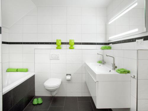 een witte badkamer met een toilet en een wastafel bij Beautiful group accommodation with hot tub and Finnish kota, located in Twente in Losser