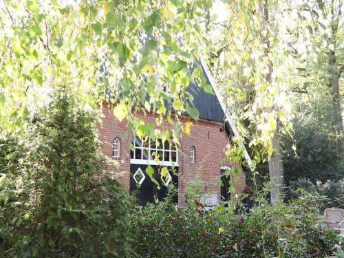 a red brick building with a window in a garden at Beautiful holiday home with hot tub in Losser