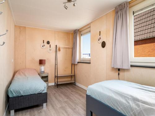 a bedroom with two beds and a window at Disabled house on the water, on a holiday park in Friesland in Akkrum
