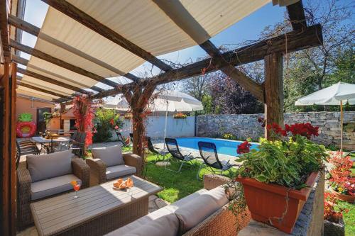 a patio with a table and chairs and a pool at Villa in Batlug with Private Pool in Batlug