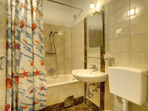 a bathroom with a sink and a toilet and a tub at Villa in Batlug with Private Pool in Batlug