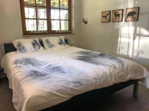uma cama grande num quarto com uma janela em Beautiful wooden chalet with large garden and balcony, located in Barvaux em Barvaux
