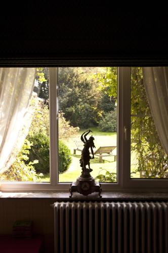 a statue in front of a window with a view at Walden in Lo-Reninge