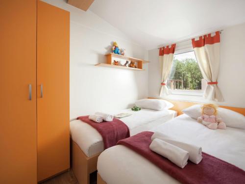 a bedroom with two beds with stuffed animals on them at Modern chalet with 2 bathrooms and a veranda in Vrsar