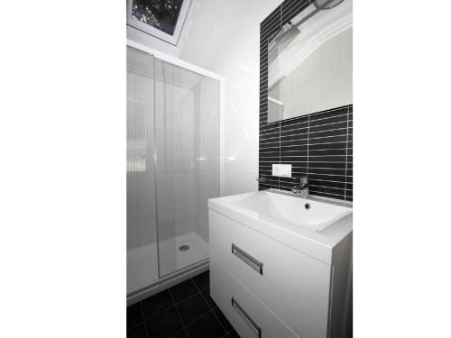 a bathroom with a white sink and a shower at Chalet on Texel with Private Sauna in Den Hoorn