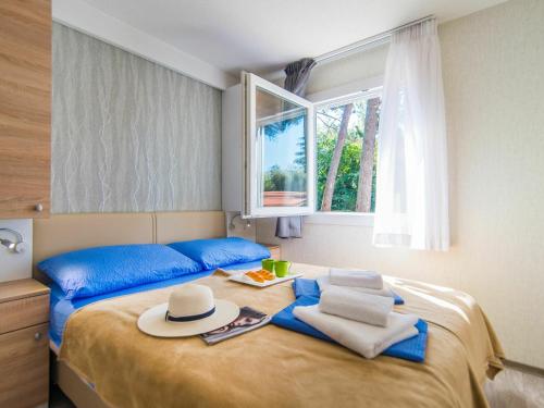 班約勒的住宿－Nice chalet with 2 bathrooms and a dishwasher 15km from Pula，一间卧室配有带帽子和窗户的床