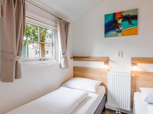 Posteľ alebo postele v izbe v ubytovaní Cozy chalet with covered terrace, in a holiday park on the Leukermeer