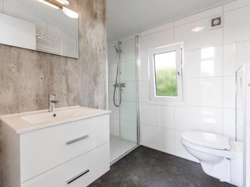 ein weißes Bad mit einem Waschbecken und einem WC in der Unterkunft Nice chalet with a dishwasher, in a holiday park at a recreational lake in Lathum