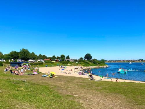 a group of people on a beach near the water at Chalet in Gelderland with Spacious Garden in Lathum