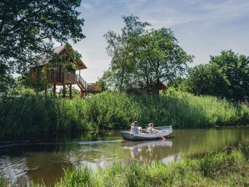 Beautiful wooden tree house with terrace in a holiday park on the river De Regge