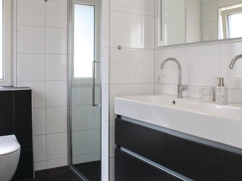 een witte badkamer met een wastafel en een toilet bij Atmospheric villa on the water, at a holiday park in Friesland in Idskenhuizen