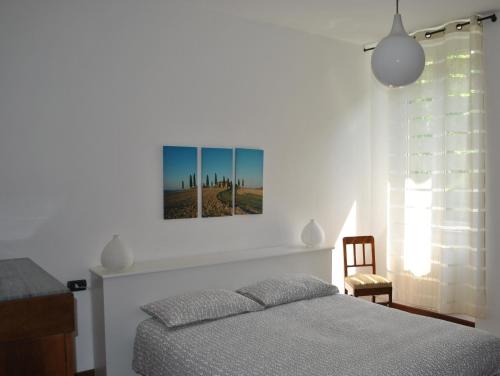 Oliveto Lario的住宿－Villa Ortensia，卧室配有一张床,墙上挂有绘画作品