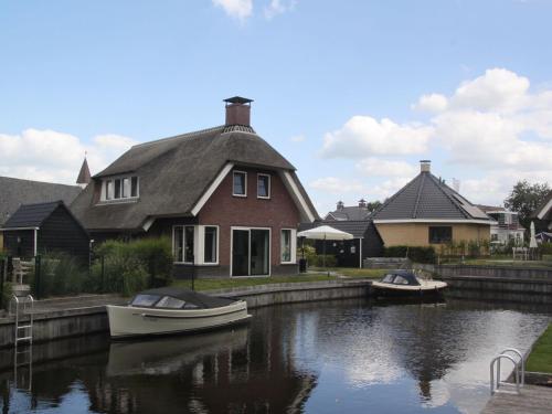 two boats are docked in a house on a canal at Villa in Friesland with Sauna & Bubble Bath in Idskenhuizen