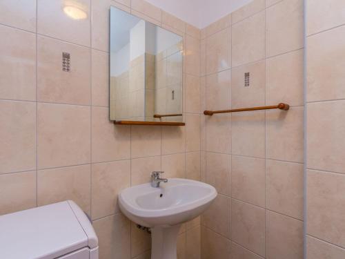 uma casa de banho com um lavatório, um espelho e um WC. em Peaceful Apartment in Pula with Swimming Pool em Valtura