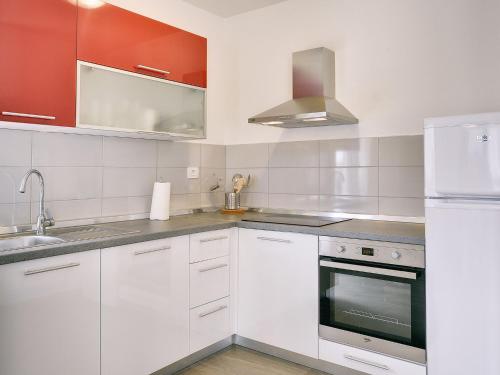 a kitchen with white cabinets and a sink and a refrigerator at Villa in Barban near Beach & Pool in Rebići