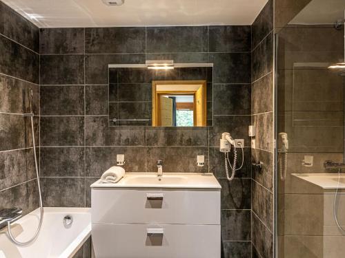 a bathroom with a sink and a shower and a mirror at Chalet in French Alps with Mountain Views in Abondance