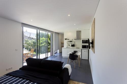a living room with a couch and a kitchen at Quinta das Rosas Villas in Ribeira Grande