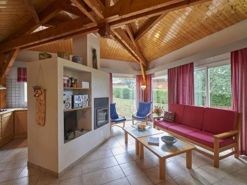 un salon avec un canapé rouge et une table dans l'établissement Pet-Friendly Home w Garden, à Quillan