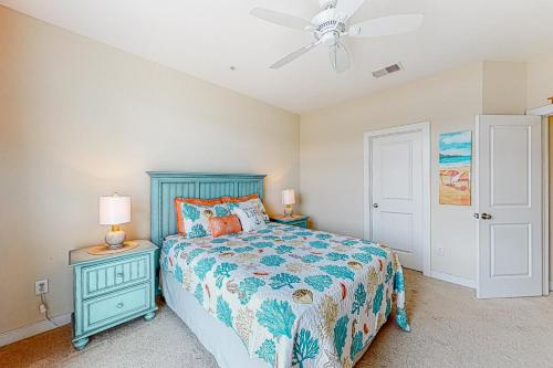 una camera con letto blu e ventilatore a soffitto di Seaside Village - SunnyG a Ocean City