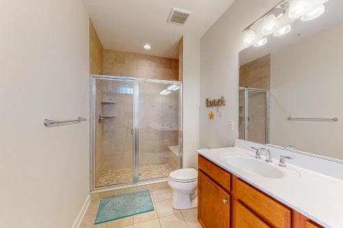 een badkamer met een douche, een wastafel en een toilet bij Seaside Village - SunnyG in Ocean City