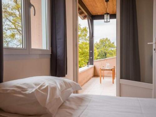 1 dormitorio con cama y vistas a un balcón en Spacious and modern villa with large garden and BBQ area en Les Forges