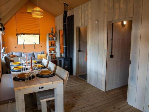 a dining room and living room with a table at Glamping Tent by Lake De Rhederlaag in Lathum