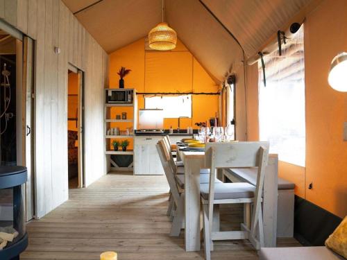a kitchen and dining room with a table and chairs at Glamping Tent by Lake De Rhederlaag in Lathum