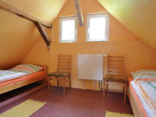 Habitación en el ático con 2 camas y 2 sillas en Cosy holiday home in the Harz region, en Herzberg am Harz
