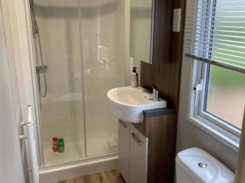 a bathroom with a shower and a sink at Comfort chalet on a recreational lake in Lathum