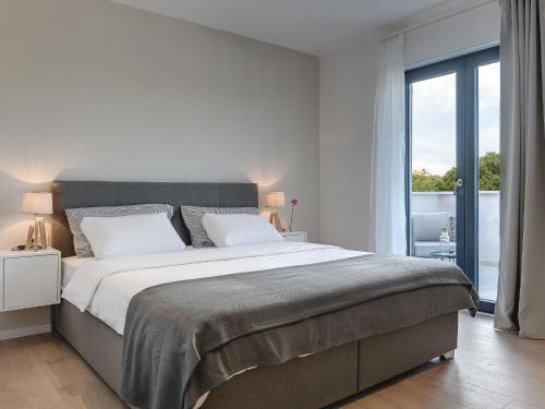 Un dormitorio blanco con una cama grande y una ventana en Modern villa swimming pool , outdoor kitchen and fenced garden en Pula