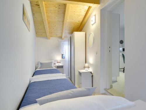 Duas camas num quarto com paredes brancas e tectos em madeira em Detached house with private pool, 15 minutes drive from the coast em Vodnjan
