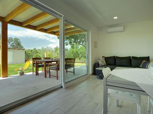 a living room with a sliding glass door with a table at Modern, detached holiday home with enclosed garden, near the centre and the beach in Fažana