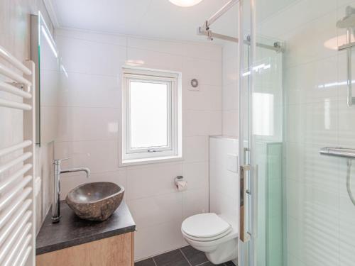 a bathroom with a sink and a toilet and a window at Chalet in Duisburg with Beach and Harbor Views in Well